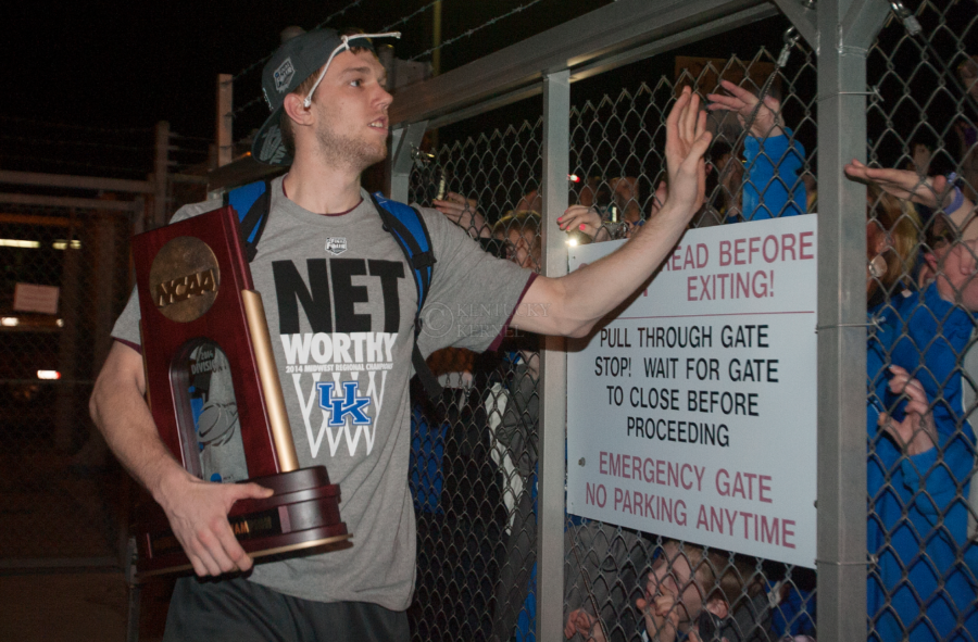 UK guard Jon Hood high fives fans and holds the West Regional Championship trophy after returning to Lexington following UKs Elite 8 victory over Michigan on Sunday, March 30, 2014. Photo by Michael Reaves