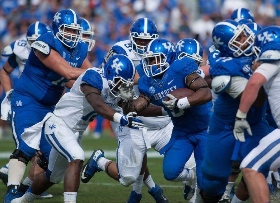 Running+back+Jojo+Kemp+is+assaulted+by+defenders+during+the+Blue%2FWhite+Spring+Game+in+Lexington%2C+Ky.%2C+on+Saturday%2C+April+26%2C+2014.+Blue+defeated+White+38-14.+Photo+by+Adam+Pennavaria