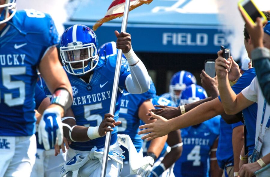 Kentucky+running+back+Braylon+Heard+carries+an+American+flag+out+of+the+tunnel+before+the+first+half+of+the+University+of+Kentucky+vs.+University+of+Tennessee+Martin+football+game+at+Commonwealth+Stadium+in+Lexington%2C+Ky.%2C+on+Saturday%2C+August+30%2C+2014.+Kentucky+leads+Tennessee+Martin+35+to+0.+Photo+by+Adam+Pennavaria