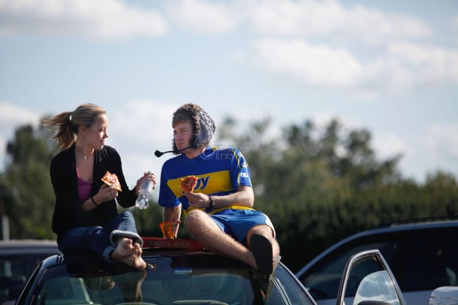 Vocal performance senior Amanda Maddox and UK Alum Dave Dervis Smith sit on their car and eat pizza in the Arboretum parking lot on Monday, September 28, 2009. Photo by Zach Brake