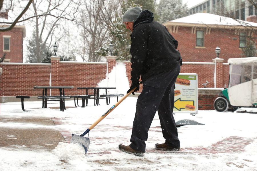 A UK facilities worker shovels the sidewalk after the first snowfall on campus of 2016 on Wednesday, January, 20, 2015 in Lexington, KY.