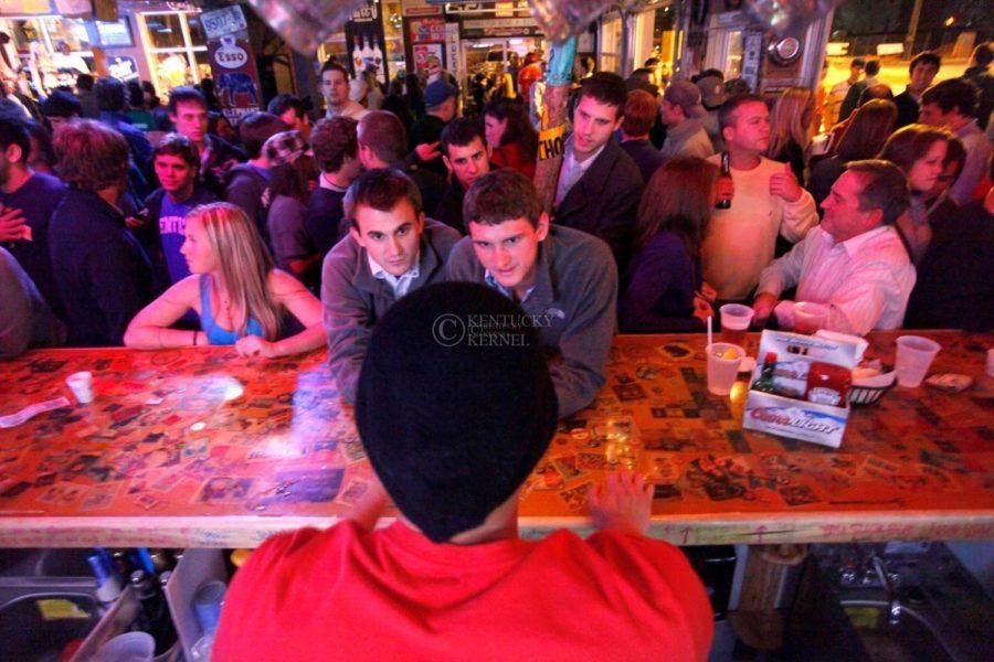 UK alum and Tin Roof bartender Topher Aldridge takes drink orders from BRian Britt, left, and Brian Knight Friday night during the South Limestone Block Party to benefit the Huntsman Cancer Foundation..Photo by Zach Brake