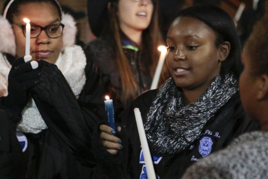 A student lights anothers candle during a meeting for prayer and reflection on the night following the U.S. presidential election in front of Patterson Office Tower at the University of Kentucky in Lexington, Ky., on Wednesday, November 9, 2016. UKs chapter of the National Pan-Hellenic Council, the coordinating body of nine historically African-American sororities and fraternities on campus, hosted the meeting. Photo by Joshua Qualls | Staff
