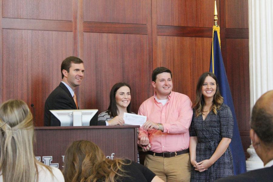 Attorney General Andy Beshear presents a check to UK Pofessor Pastel and two of her students.