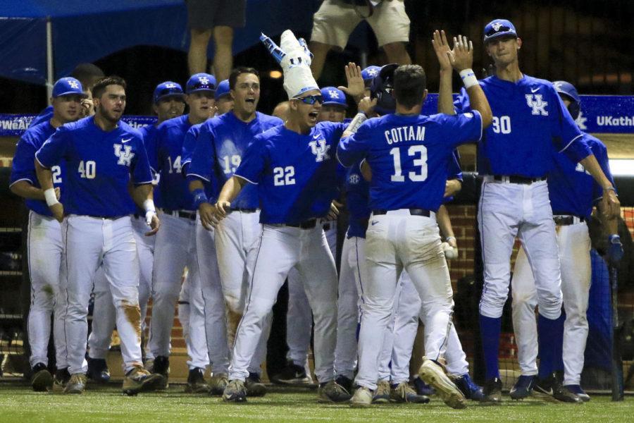 Kentucky Wildcats catcher Kole Cottam is greeted by teammates after scoring a run in the sixth inning of the region championship game of the Lexington Regional at Cliff Hagan Stadium on Sunday, June 4, 2017 in Lexington, KY. Photo by Addison Coffey | Staff.