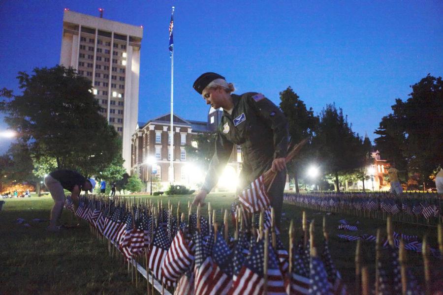 Stephanie Imeson arranges flags for the 9/11 memorial in front of the main building in Lexington, Kentucky on Tuesday, Sept. 10, 2013. Photo by Emily Wuetcher | Staff