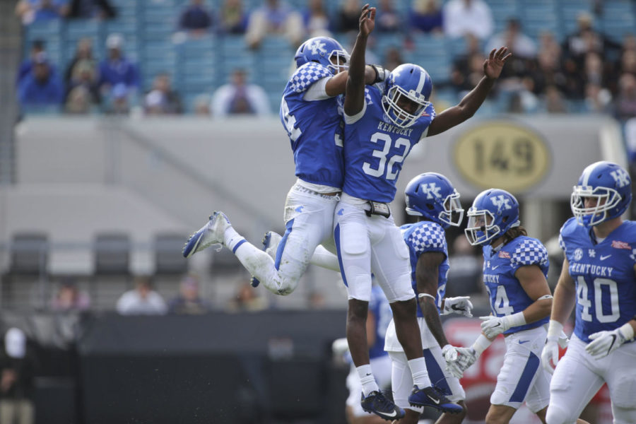 Linebacker Jordan Jones #34 of the Kentucky Wildcats celebrates with linebacker Eli Brown #32 after a tackle during the first half of the TaxSlayer Bowl against the Georgia Tech Yellow Jackets at EverBank Field on Saturday, December 31, 2016 in Jacksonville, Florida. Photo by Michael Reaves | Staff.