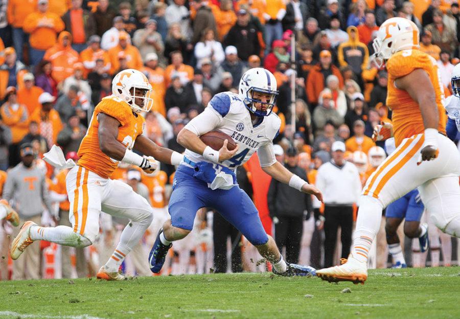 Kentucky quarterback Patrick Towles tries to avoid the Tennessee defense during a run during the first half of the University of Kentucky vs. University of Tennessee mens football game at Neyland Stadium in Lexington, Tn., on Friday, November 14, 2014 Photo by Jonathan Krueger