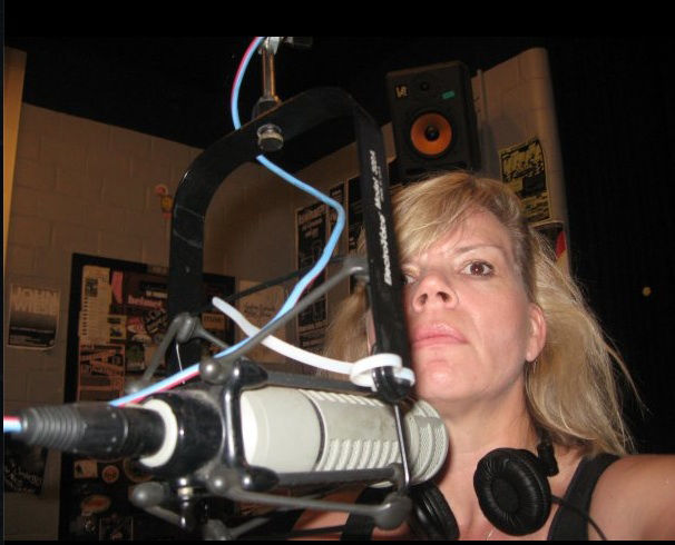 Kakie Urch at the WRFL mic in the Student Center studios as a professor of multimedia in the School of Journalism and multimedia. 