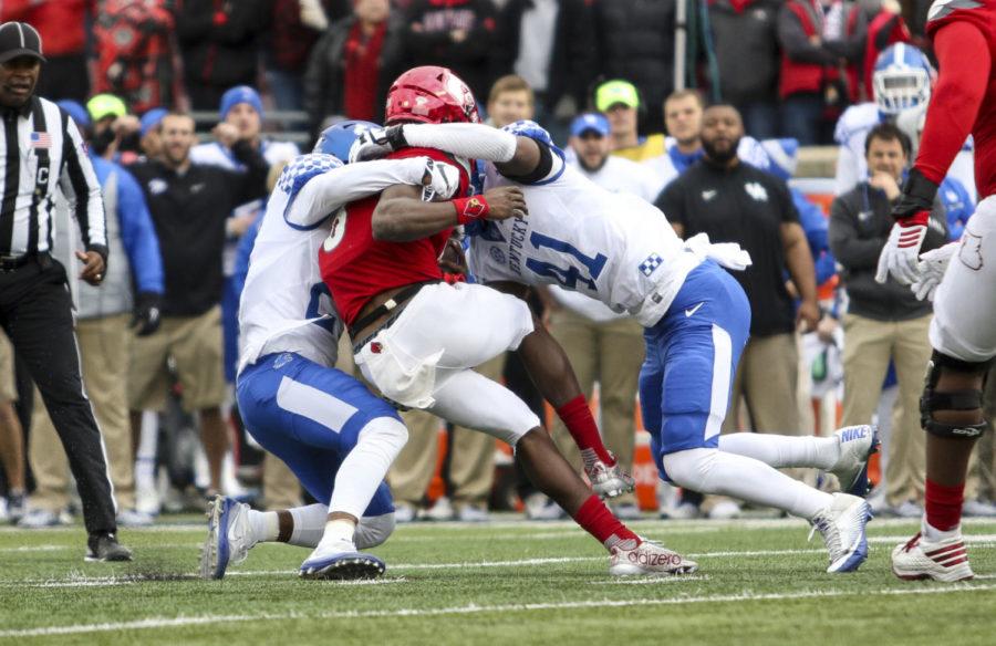 Kentuckys Mike Edwards and Josh Allen tackle Lamar Jackson during the Wildcats game against the Louisville Cardinals at Papa Johns Stadium on November 26, 2016 in Louisville, Kentucky.