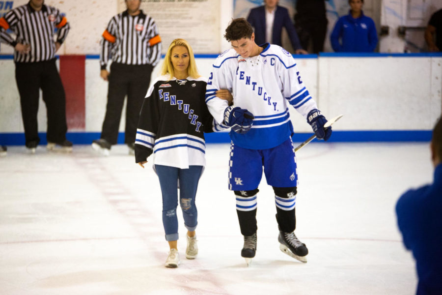 A UK Hockey player escorts Kindly Myers onto the ice to drop the first puck before the teams game against the Akron Zips on Friday, Sept. 7, 2018, at the Lexington Ice Center in Lexington, Kentucky. Photo by Jordan Prather | Staff