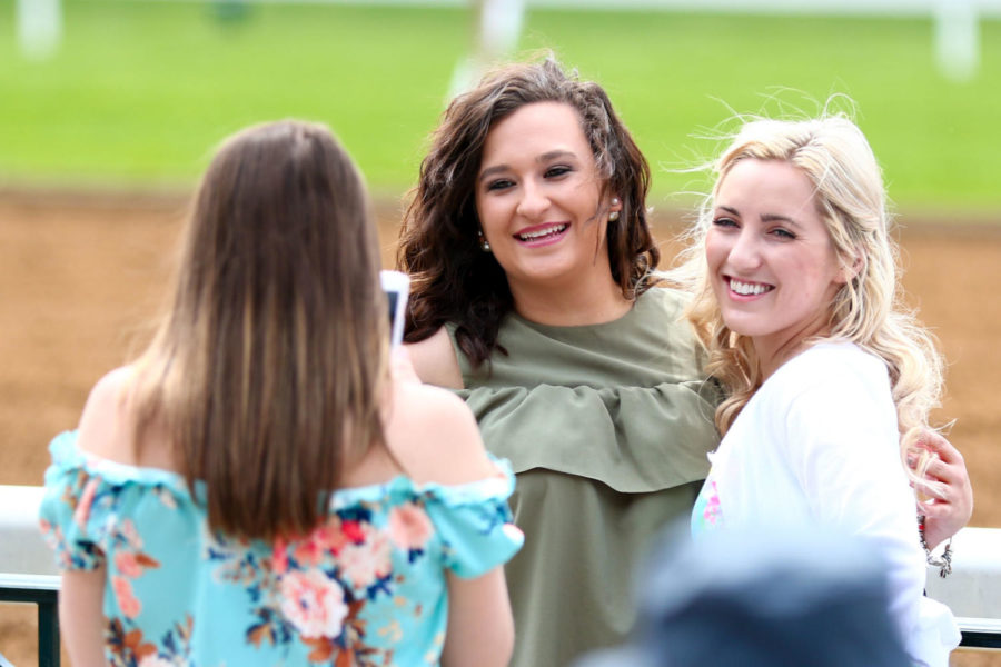 Spectators pose for a picture in front of the track during the first day of Keenelands spring meet on Friday, April 6, 2018, in Lexington, Kentucky. Photo by Arden Barnes | Staff