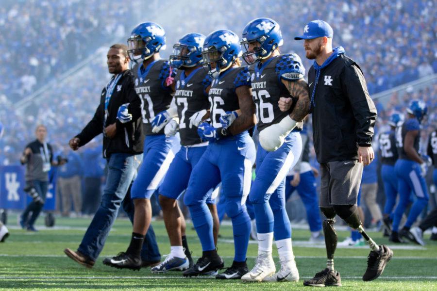 UKs captains walk out with a wounded veteran before the start of the game. University of Kentucky football lost to No. 6 Georgia 34-17 at Kroger Field on Saturday, November 3, in Lexington, Kentucky. Photo by Michael Clubb | Staff