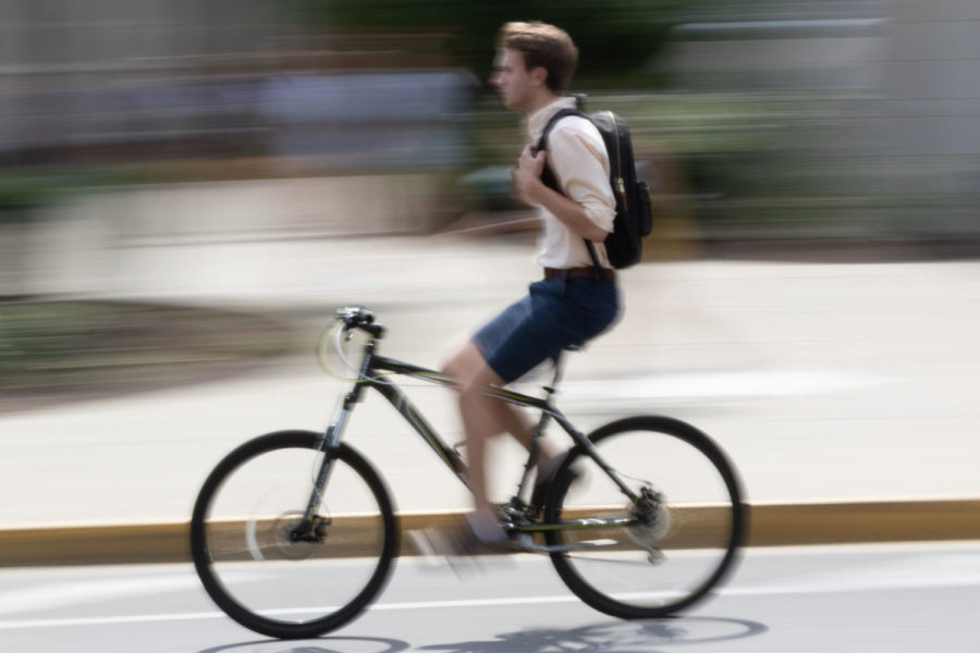 A student speeds by on a bicycle during class change on Wednesday, September 19th, 2018 in Lexington, Kentucky. Photo by Michael Clubb | Staff