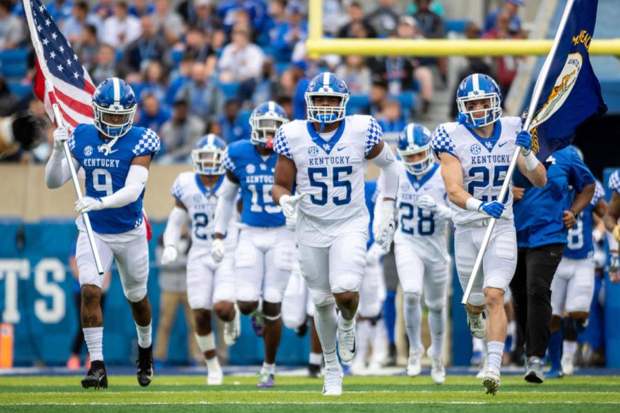 Kentucky Wildcats defensive lineman Davoan Hawkins (55) runs out with safety Davonte Robinson (9) and wide receiver Brett Slusher (25). University of Kentucky’s football team played their annual spring game on Friday, April 12, 2019 at Kroger Field. The Blue team won 64-10. Photo by Michael Clubb | Staff