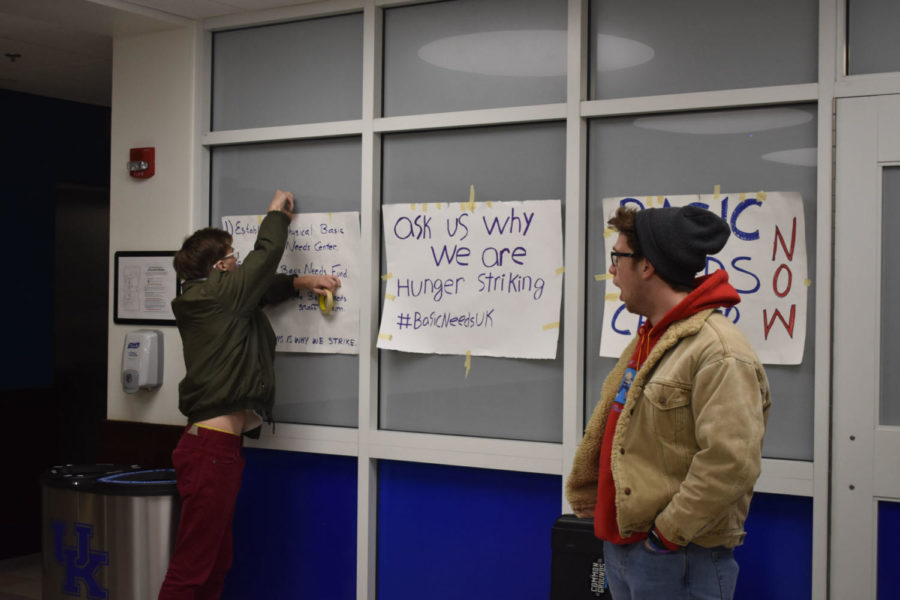 A student hangs up posters from the Basic Needs campaign in the first floor of the Main Building on UKs campus as part of the occupation by the Black Student Advisory Council and the Basic Needs Campaign on Monday, April 1, 2019 in Lexington, Kentucky. Photo by Natalie Parks | Staff