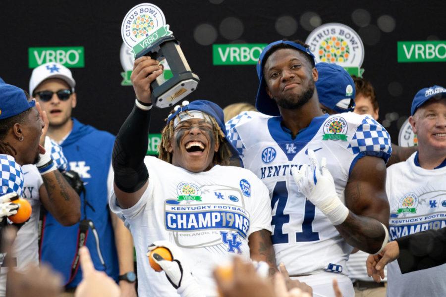 Kentucky Wildcats running back Benny Snell Jr. (26) holding up his MVP trophy while Kentucky Wildcats linebacker Josh Allen (41) celebrates after winning the Citrus Bowl. University of Kentucky football defeated Penn State University 27-24 in the VRBO Citrus Bowl at Camping World Stadium on Tuesday, January 1, 2019 in Orlando, Florida. Photo by Michael Clubb | Staff