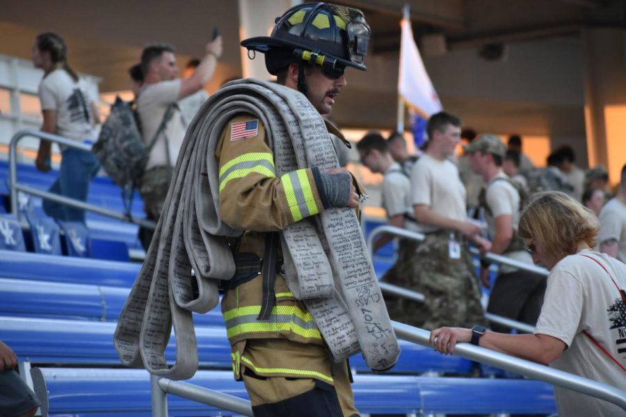 Doug Thompson carries a hose with the names of all 343 firefighters who were killed on 9/11 written on it as he leads the 9/11 Memorial Stair Climb on Wednesday, September 11, 2019 in Lexington, Kentucky. Photo by Natalie Parks | Staff
