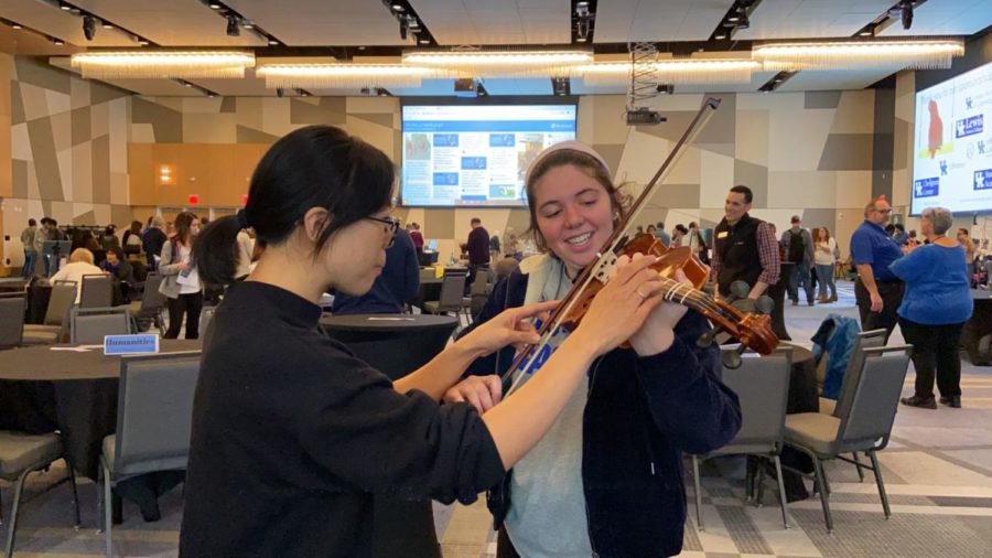 Tze-Ying Wu helps Shan Jennings hold a viola and play the opening notes of Twinkle, Twinkle, Little Star as part of Dr. Wus booth at the Curiosity Fair in UKs Gatton Student Center on October 29, 2019. Photo by Natalie Parks | Staff