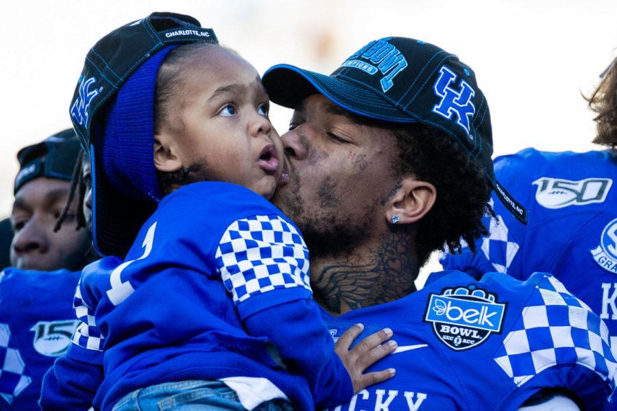 Kentucky Wildcats quarterback Lynn Bowden Jr. (1) kisses his son Lynn Bowden III after the Belk Bowl football game between Kentucky and Virginia Tech on Tuesday, Dec. 31, 2019, at Bank of America Stadium in Charlotte, North Carolina. UK won 37-30. Photo by Michael Clubb | Staff