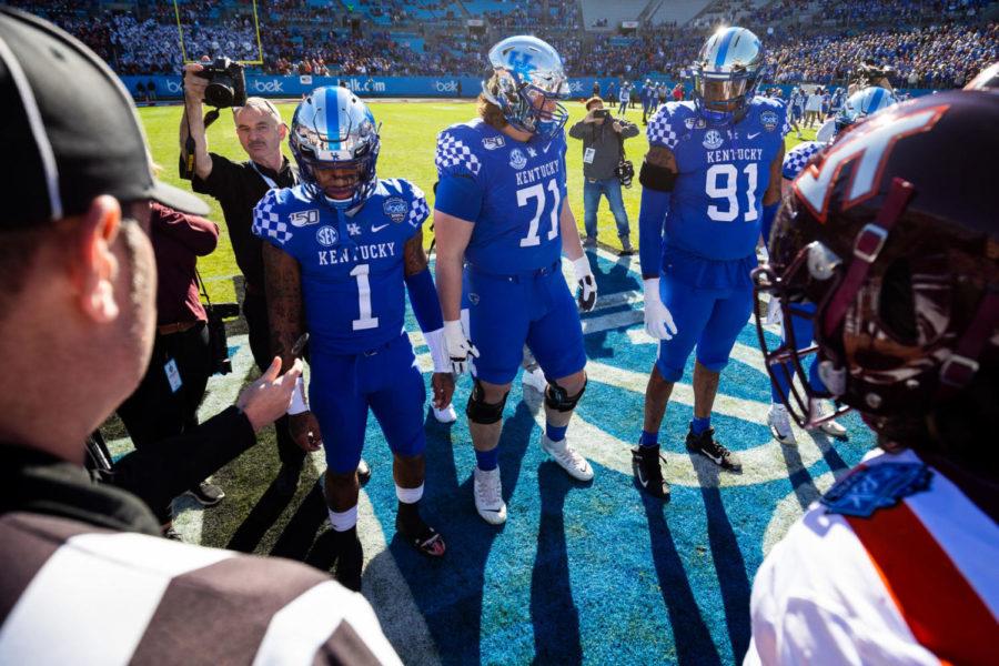 Kentucky Wildcats quarterback Lynn Bowden Jr. (1), offensive guard Logan Stenber (71), and defensive end Calvin Taylor Jr. (91) watch the coin toss before the Belk Bowl football game between Kentucky and Virginia Tech on Tuesday, Dec. 31, 2019, at Bank of America Stadium in Charlotte, North Carolina. UK won 37-30. Photo by Michael Clubb | Staff