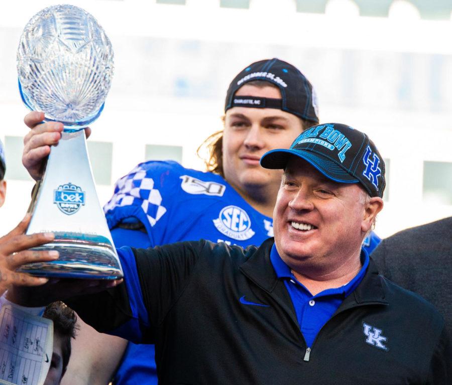 Kentucky head coach Mark Stoops hold up the Belk Bowl trophy after Kentucky won the game against Virginia Tech on Tuesday, Dec. 31, 2019, at Bank of America Stadium in Charlotte, North Carolina. Kentucky won 37-30. Photo by Jordan Prather | Staff