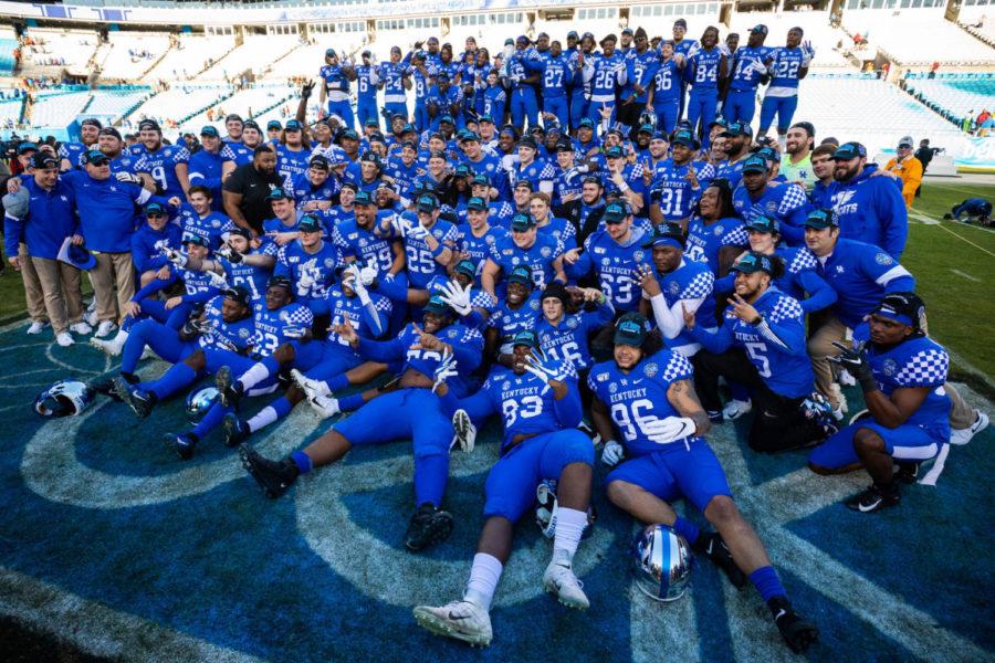 UK poses for a photo with the trophy after the Belk Bowl football game between Kentucky and Virginia Tech on Tuesday, Dec. 31, 2019, at Bank of America Stadium in Charlotte, North Carolina. UK won 37-30. Photo by Michael Clubb | Staff