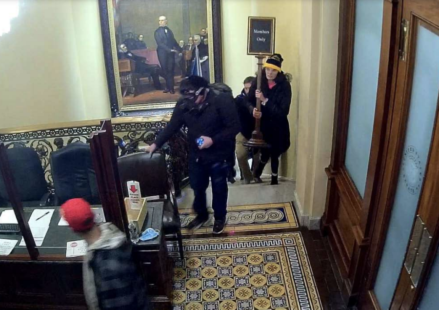In footage from Capitol Police and provided to the FBI, Courtright (in the black and yellow hat) can be seen carrying a sign from the Capitol building during the riot on Jan. 6, 2021. Photo from the federal affidavit detailing Courtrights charges.
