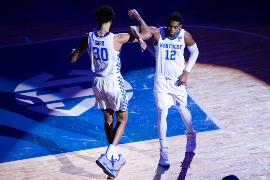 Kentucky Wildcats forward Keion Brooks Jr. (12) locks arms with Kentucky Wildcats forward Oliver Sarr (30) during introductions before the University of Kentucky vs. Louisiana State University men's basketball game on Saturday, Jan. 23, 2021, at Rupp Arena in Lexington, Kentucky. UK won 82-69. Photo by Michael Clubb | Staff