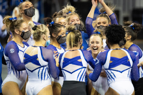 Teammates surround Raena Worley after her floor routine during the University of Kentucky vs. Arkansas gymnastics meet on Friday, Feb. 12, 2021, at Memorial Coliseum in Lexington, Kentucky. UK won 197.000-196.675. Photo by Michael Clubb | Staff