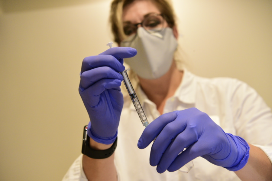 A researcher preps a syringe with a COVID-19 vaccine as part of the Johnson & Johnson trial. Photo provided by ENSEMBLE research group. 