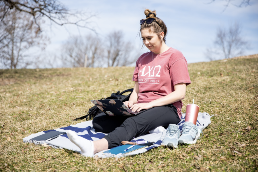 Madeleine Spencer, a freshman environmental science and natural resources major, does homework while enjoying the warm weather on Wednesday, March 10, 2021, outside of William T. Young Library in Lexington, Kentucky. Photo by Jack Weaver | Staff