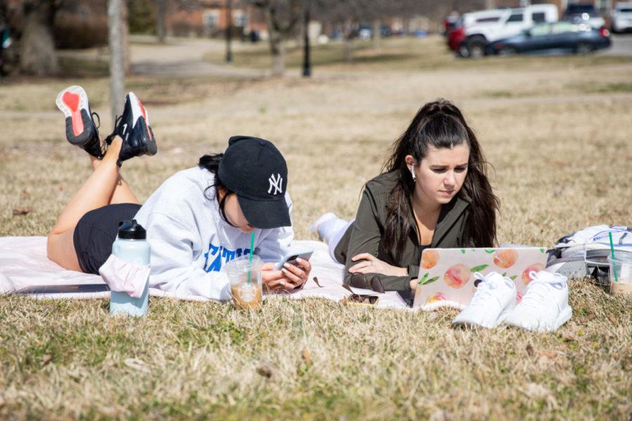 Two+UK+students+sign+up+for+graduation+while+enjoying+the+warm+weather+on+Wednesday%2C+March+10%2C+2021%2C+outside+of+William+T.+Young+Library+in+Lexington%2C+Kentucky.+Photo+by+Jack+Weaver+%7C+Staff