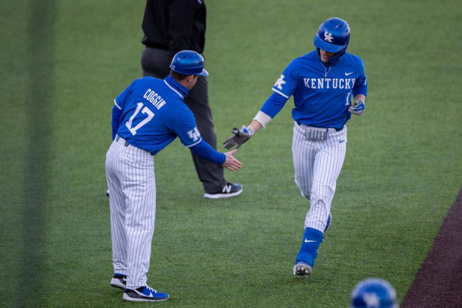 Kentucky Wildcat John Rhodes (1) high fives a coach while running in to home plate during the University of Kentucky vs. Eastern Kentucky University baseball game on Tuesday, March 2, 2021, at Kentucky Proud Park in Lexington, Kentucky. UK won 6-3 Photo by Michael Clubb | Staff