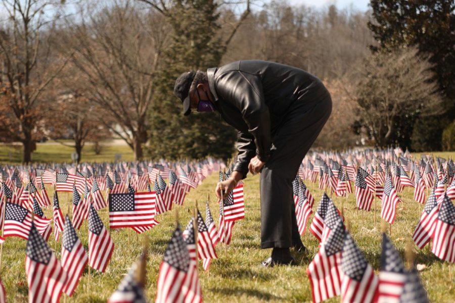 Dr. Walter Malone of Canaan Christian Church plants a flag in memory of Kentuckians lost to COVID-19 during a memorial service on March 6, 2021, in Frankfort, Kentucky. Photo by Martha McHaney