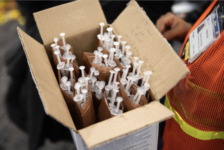 A box of COVID-19 vaccines is carried to vaccine stations on Saturday, Jan. 30, 2021,  in Lexington, Kentucky. Photo by Jack Weaver | Staff