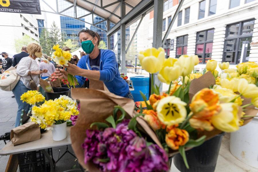 A Bellaire Blooms employee gathers flowers on Saturday, April 10, 2021, at the Lexington Farmers Market at Fifth Third Pavilion in Lexington, Kentucky. Photo by Jack Weaver | Staff