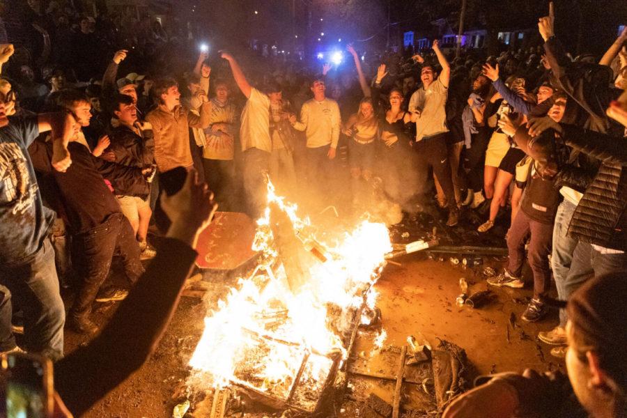 UK students dance to music being played on a speaker while gathered around a burning couch on State Street on Saturday, April 24, 2021, in Lexington, Kentucky as students celebrate Kentucky volleyball’s national championship win. Photo by Jack Weaver | Staff