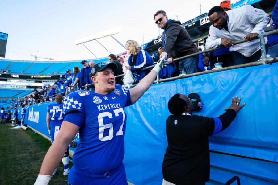 Kentucky Wildcats offensive tackle Landon Young (67) high fives fans after the Belk Bowl football game between Kentucky and Virginia Tech on Tuesday, Dec. 31, 2019, at Bank of America Stadium in Charlotte, North Carolina. UK won 37-30. Photo by Michael Clubb | Staff
