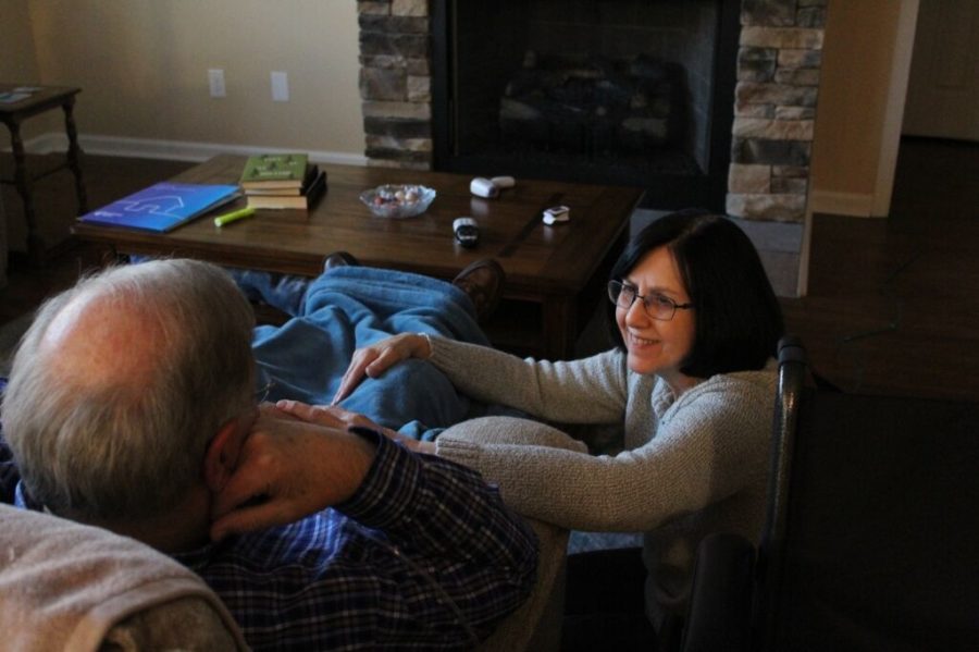Anita Crick kneels by her husband, Rodney, after measuring his blood oxygen levels on Feb. 22, 2021, in Nicholasville, Kentucky. Rodney recently returned home after a month of being hospitalized for COVID-19. Photo by Rachel Crick.