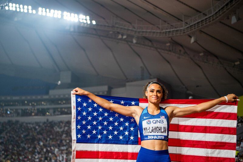 Former Kentucky Wildcat Track and Field star poses with the American Flag at the 2019 World Athletics Championsips. 