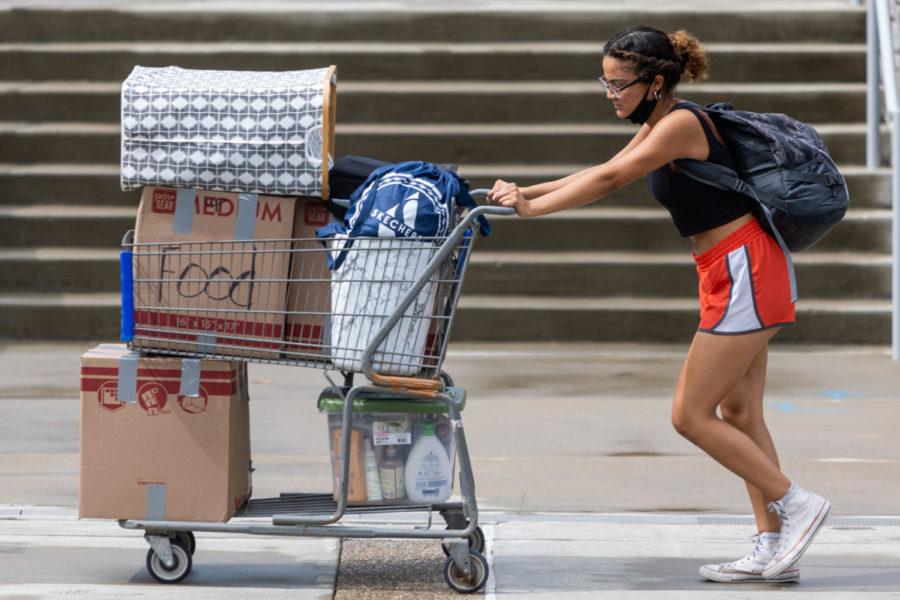 A student pushes a cart of belongings past the Gatton Student Center during move in on Monday, Aug. 16, 2021, in Lexington, Kentucky. Photo by Jack Weaver | Staff