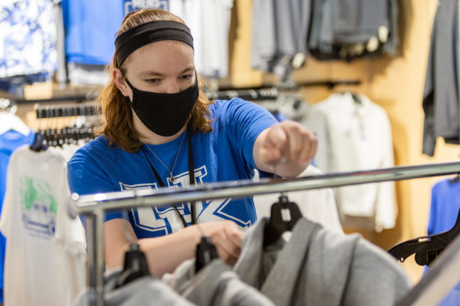 Kayla Holleran, a senior accounting major and UK Bookstore employee, hangs merchandise on Wednesday, Sept. 29, 2021, at the UK Bookstore in Lexington, Kentucky. Photo by Jack Weaver | Staff