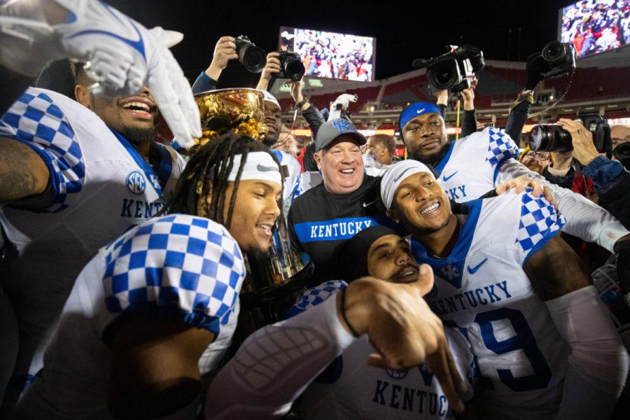 Kentucky Wildcats head coach Mark Stoops, center, poses for photos with his players the the Governor’s Cup trophy after the UK vs. Louisville Governor’s Cup football game on Saturday, Nov. 27, 2021, at Cardinal Stadium in Louisville, Kentucky. UK won 52-21. Photo by Michael Clubb | Staff