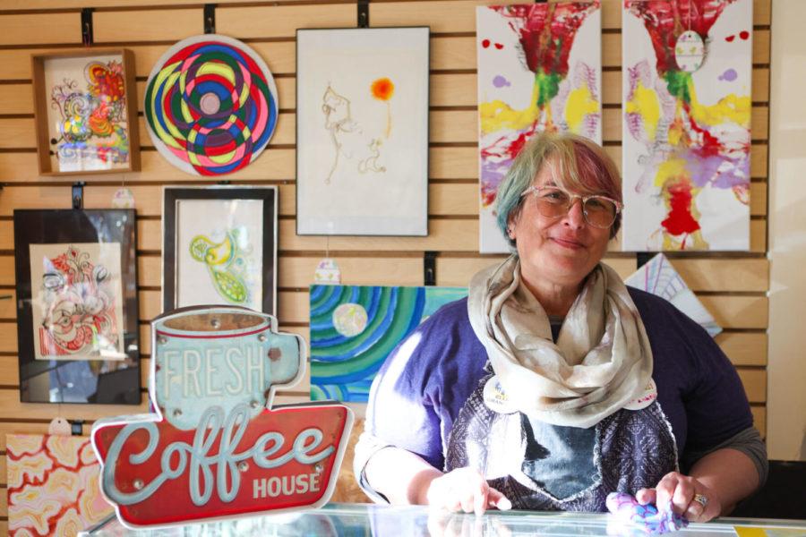 Ellie Harman, co-owner of High on Art & Coffee, poses for a portrait in front of her art on Tuesday, November 30, 2021, in Lexington, KY.