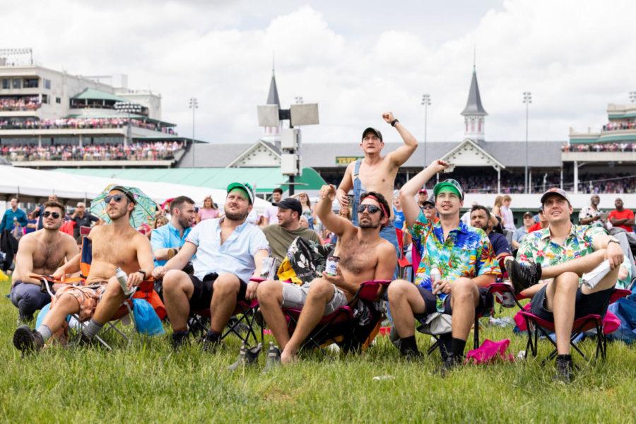 A group of Oaks goers from the Chicago area watch a race on a video board in the infield on Oaks Day at Churchill Downs on Friday, May 6, 2022, in Louisville, Kentucky. Photo by Jack Weaver | Staff