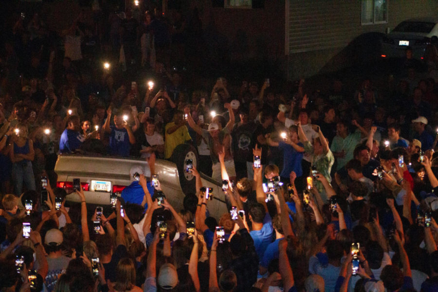 People surround a flipped car on State Street after UK fans gathered following Kentucky footballs win over Florida on Sept. 10, 2022. Photo by Maria Rauh | Kentucky Kernel