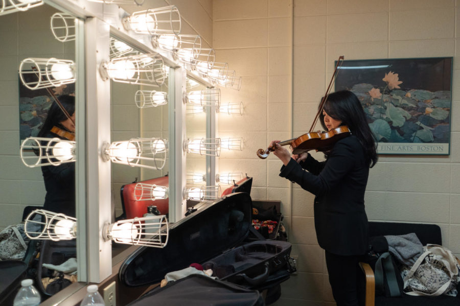 Violinist Reisa Fukuda practices her violin part in the mirror of a dressing room on Friday, Sept. 23, 2022, at Singletary Center for the Arts in Lexington, Kentucky. Photo by Carter Skaggs | Kentucky Kernel