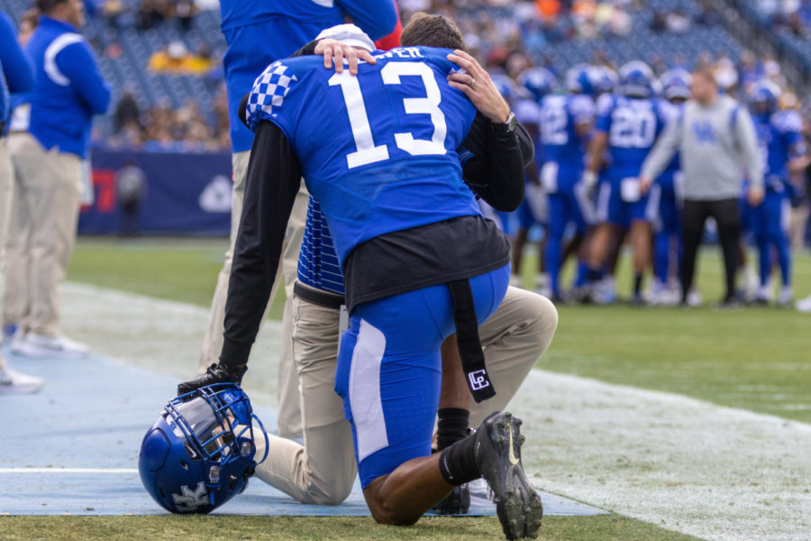 Kentucky Wildcats linebacker J.J. Weaver (13) shares a moment with a coach before the Kentucky vs. Iowa Music City Bowl football game on Saturday, Dec. 31, 2022, at Nissan Stadium in Nashville, Tennessee. UK lost 21-0. Photo by Travis Fannon | Staff