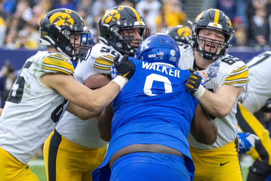 Kentucky Wildcats defensive tackle Deone Walker (0) is blocked by three Iowa players during the Kentucky vs. Iowa Music City Bowl football game on Saturday, Dec. 31, 2022, at Nissan Stadium in Nashville , Tennessee. UK lost 21-0. Photo by Travis Fannon | Staff